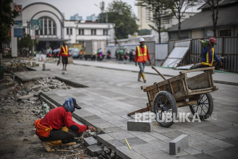 Pekerja menyelesaikan proyek revitalisasi pedestrian di kawasan Kota Tua Jakarta, Selasa (17/5/2022). Gubernur DKI Jakarta Anies Baswedan sebut revitalisasi trotoar jadi tren kota dunia.