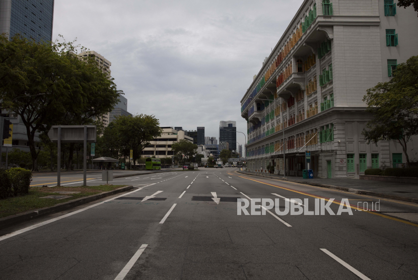Suasana jalanan yang kosong di depan gedung Kementerian Komunikasi dan Informasi di Singapura, Selasa (7/4). Sebagian besar jalan-jalan dan pusat perbelanjaan terlihat kosong pada hari pertama penutupan tempat-tempat kerja yang tidak esensial di Singapura hal ini sebagai bagian dari langkah pemerintah untuk memutus rantai dalam memerangi pandemi Covid-19 dan coronavirus