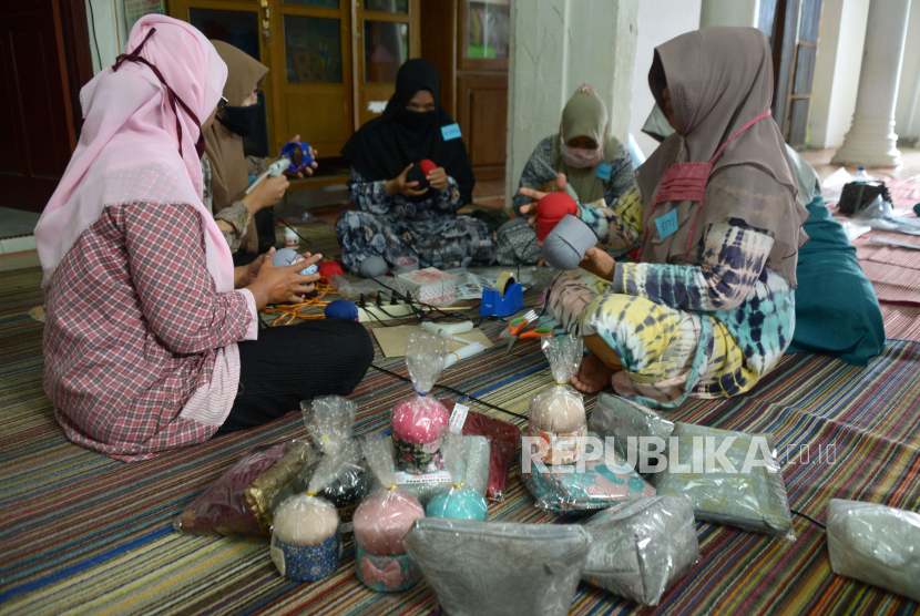 Sejumlah ibu rumah tangga mengikuti pelatihan membuat produk kerajinan souvenir di Pusat Kegiatan Belajar Masyarakat (PKBM) Ruman Aceh, Desa Blang Cut, Banda Aceh, Aceh, Kamis (12/11/2020). Pelatihan membuat produk souvenir berupa tas dan tempat jarum pentul dari bahan baku barang bekas kain perca, gulungan karton dan busa kerjasama dengan pemerintah setempat itu dipasarkan seharga Rp10.000 untuk satu produk menurut jenisnya guna membantu perekonomian warga kurang mampu di tengah pandemi COVID-19.