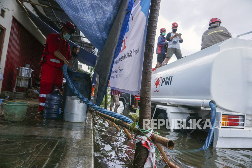 Petugas Palang Merah Indonesia (PMI) mengisi air bersih untuk dapur umum warga terdampak banjir di Pekalongan, Jawa Tengah, Jumat (19/2/2021). PMI Kota Pekalongan mendistribusikan air bersih sebanyak 1.500 liter per hari untuk warga terdampak banjir yang kekurangan air bersih. ANTARA FOTO/Harviyan Perdana Putra/rwa.