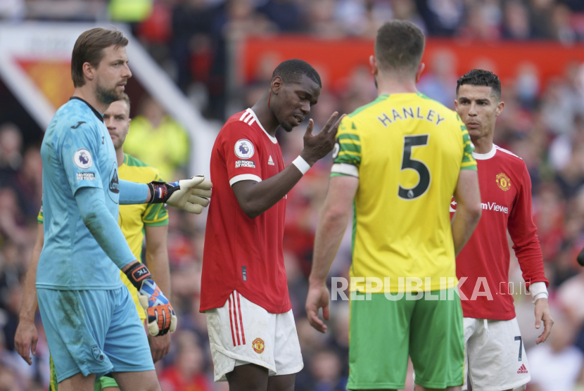 Pemain Manchester United Paul Pogba menyeka darah dari wajahnya selama pertandingan sepak bola Liga Inggris antara Manchester United dan Norwich City di stadion Old Trafford di Manchester, Inggris, Sabtu, 16 April 2022.