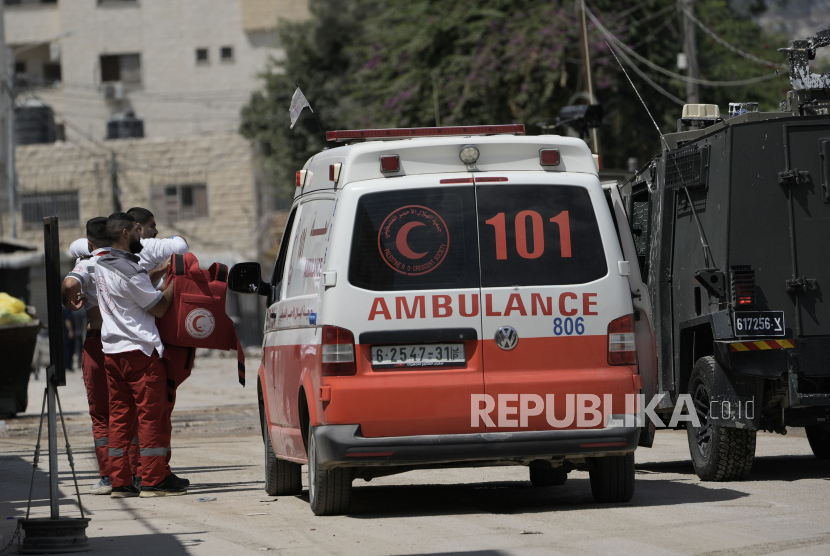 Seorang paramedis Palestina menunjukkan rompi antipelurunya kepada anggota pasukan Israel yang ada dalam kendaraan lapis bajam saat operasi militer di kota Jenin, Tepi Barat, Rabu (28/8/2024). Bentrokan dengan militer Israel di Tepi Barat meningkat tajam sejak dimulainya perang Israel-Hamas di Gaza.