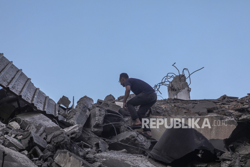  Seorang Palestina memeriksa puing-puing rumahnya yang hancur setelah serangan udara Israel, di Kota Gaza, 19 Mei 2021. 