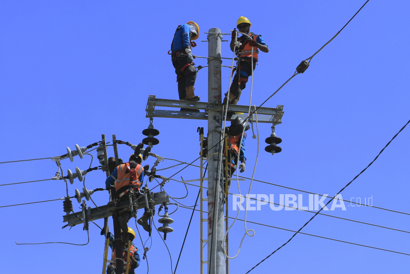 Sejumlah petugas PLN memindahkan jaringan kabel dari tiang listrik yang lama ke tiang yang baru di Kecamatan Alak, Kota Kupang, NTT, Selasa (2/8/2022). PT PLN (Persero) menyiapkan enam langkah strategis untuk membawa perusahaan melaju kencang pada tahun 2023 ini.