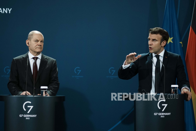 Kanselir Jerman Olaf Scholz, kiri, mendengarkan Presiden Prancis Emmanuel Macron selama konferensi pers bersama dengan Presiden Polandia Andrzej Duda, Selasa, 8 Februari 2022 di Berlin. 