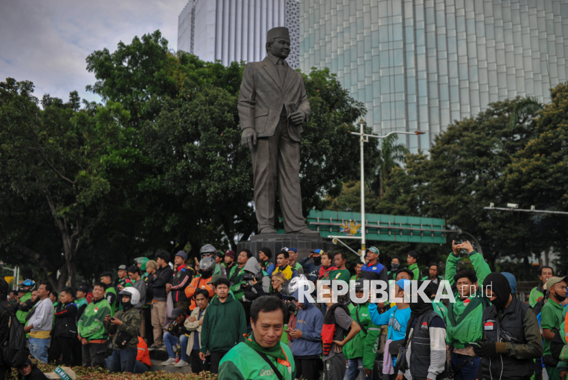 Pengemudi ojek online (Ojol) menggelar aksi di kawasan Patung Kuda, Jakarta, Selasa (20/5/2025).  Pengemudi ojek daring yang tergabung dalam Asosiasi Pengemudi Ojol Garuda Indonesia menggelar aksi disejumlah titik di Jakarta yakni di kawasan Patung Kuda, Gedung DPR RI hingga kantor Kementerian Perhubungan. Aksi tersebut digelar untuk menyuarakan sejumlah tuntutan salah satunya kebijakan potongan biaya aplikasi sebesar 20 persen oleh aplikator yang dinilai memberatkan para pengemudi ojek online.