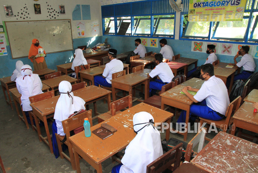 Guru mengajar pada hari pertama sekolah tatap muka di Madrasah Aliyah Negeri 1 Aceh Barat, Aceh, Senin (20/7/2020). Guna mencegah penyebaran COVID-19, pihak sekolah membagi siswa menjadi dua kelompok, yakni kelompok pertama belajar di sekolah dan lainnya belajar di rumah. ANTARA FOTO/Syifa Yulinnas/wsj.