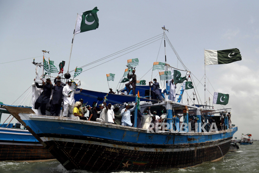 Pendukung nelayan partai berkuasa Pakistan Tehrik-e-Insaf memegang bendera nasional dan Kashmir untuk menunjukkan solidaritas dengan warga Kashmir yang tinggal di India, mengelola Kashmir di depan Yaum-e-Istehsaal (Hari Eksploitasi) di Karachi, Pakistan, 4 Agustus 2020