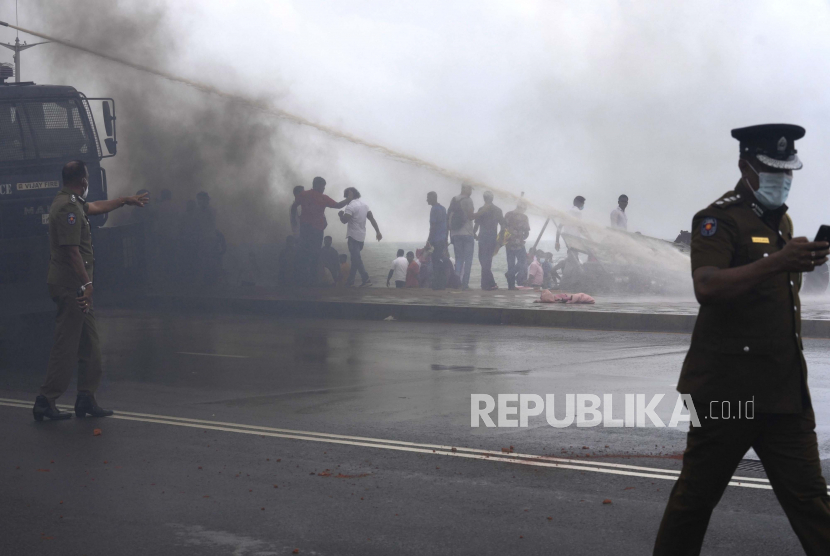  Pemrotes pro pemerintah dan anti pemerintah Sri Lanka bentrok saat polisi menembakkan water canon di luar kantor presiden di Kolombo, Sri Lanka, Senin, 9 Mei 2022. Pendukung pemerintah pada Senin menyerang pengunjuk rasa yang berkemah di luar kantor perdana menteri Sri Lanka, ketika serikat pekerja memulai Pekan Protes yang menuntut perubahan pemerintah dan presidennya untuk mundur karena krisis ekonomi terburuk yang pernah terjadi di negara itu.