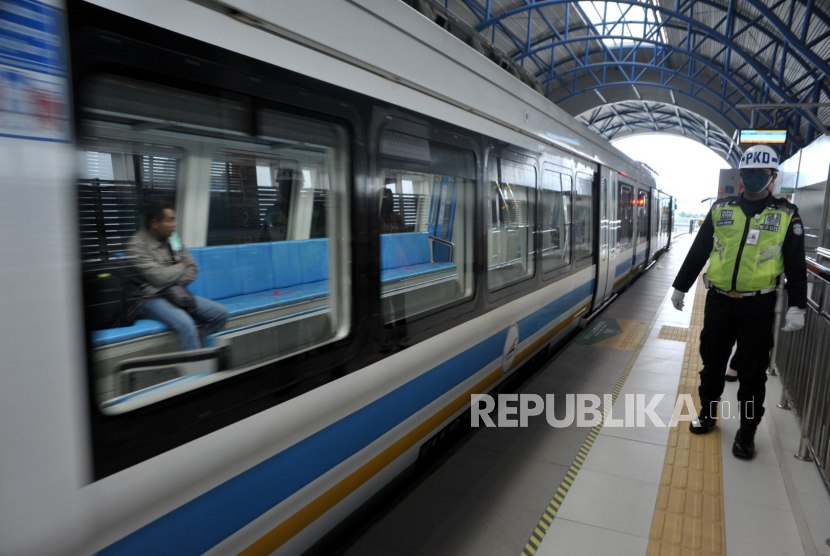 Petugas berjaga di sisi rel kereta api ringan atau  Light Rail Transit (LRT) Stasiun Dishub  Palembang, Sumsel, Selasa (31/3/2020). PT Kereta Api Indonesia (Persero) Divre III Palembang per 1 April 2020 memberlakukan pengurangan jadwal perjalanan LRT yang semula sebanyak 54 perjalanan menjadi 26 perjalanan