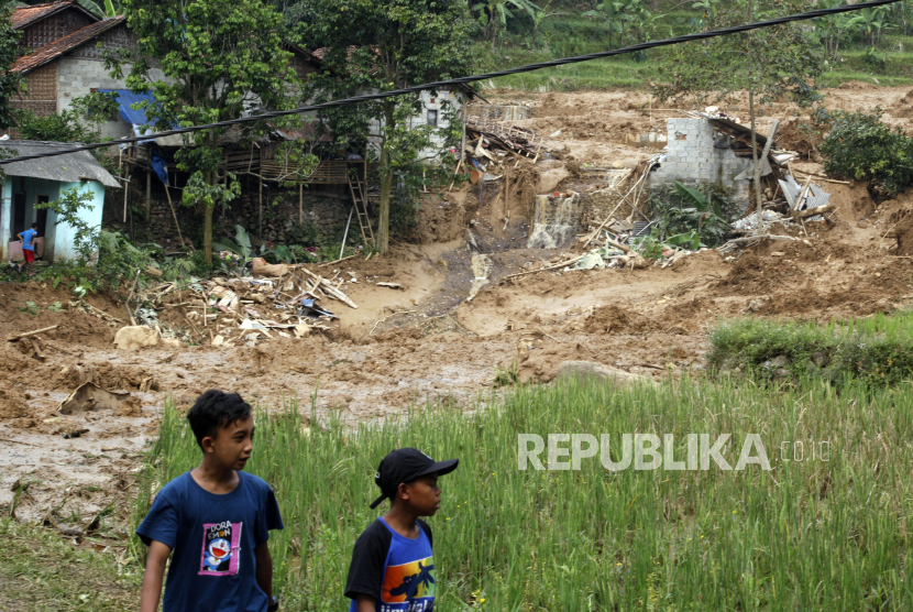 Warga melihat kondisi rumah yang rusak akibat diterjang longsor dan banjir bandang. BPBD Kabupaten Bogor menyatakan peristiwa banjir bandang disertai longsor  akibat hujan deras  yang terjadi pada malam hingga pagi hari dan mengakibatkan sejumlah rusak parah serta satu orang meninggal dunia.