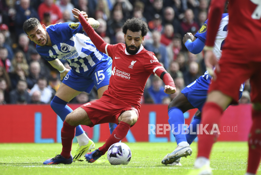 Brighton Jakub Moder, left, challenges for the ball with Liverpool