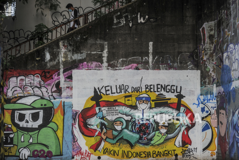 Warga turun dari tangga di dekat mural Covid-19 di kawasan Bidara Cina, Jakarta. Kenaikan kasus Covid-19 berimbas ke kenaikan angka kematian akibatnya.