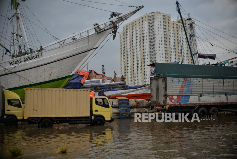 Pekerja beraktivitas saat banjir rob di Pelabuhan Sunda Kelapa, Jakarta Utara, Senin (26/12/2022). Ketua Fraksi PDIP Gembong warsono minta Pj Gubernur Heru Budi fokus atasi banjir rob.
