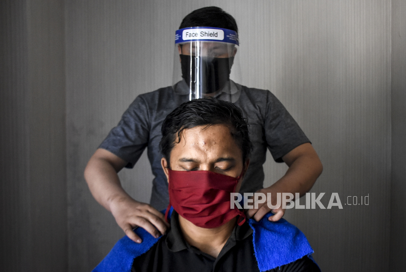 Sumatra Selatan Segera Berlakukan Denda tak Pakai Masker. Terapis tuna netra mengenakan masker dan pelindung wajah saat memijat pelanggan. Ilustrasi