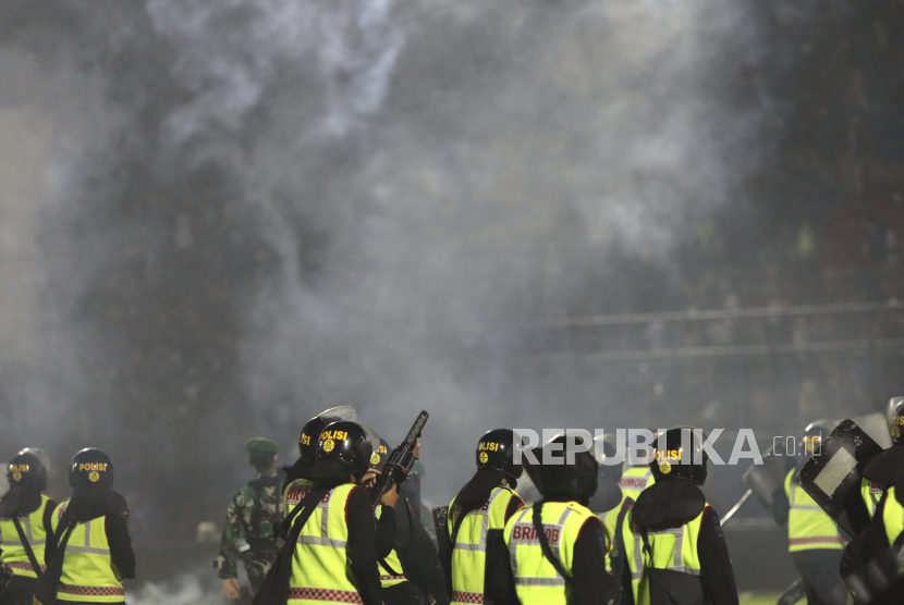  Petugas polisi menembakkan gas air mata saat kerusuhan setelah pertandingan sepak bola di Stadion Kanjuruhan di Malang, Jawa Timur, 01 Oktober 2022 (dikeluarkan pada 02 Oktober 2022). Sedikitnya 127 orang termasuk polisi tewas setelah suporter sepak bola Indonesia memasuki lapangan yang menyebabkan kepanikan dan injak-injak.