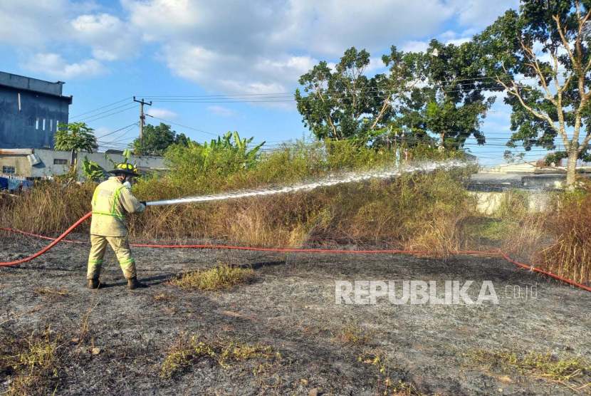 Petugas berupaya memadamkan kebakaran lahan ilalang di wilayah Kelurahan Linggajaya, Kecamatan Mangkubumi, Kota Tasikmalaya, Jawa Barat, Ahad (10/9/2023).