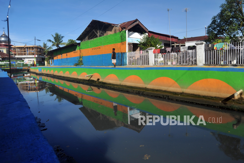 Warga melintas di kawasan sungai Bandar Purus V, Padang, Sumatera Barat. Kawasan sungai yang berada di tengah permukiman padat penduduk dan kumuh tersebut, ditata menjadi menjadi lebih bersih dan dilengkapi taman area bermain anak-anak. 