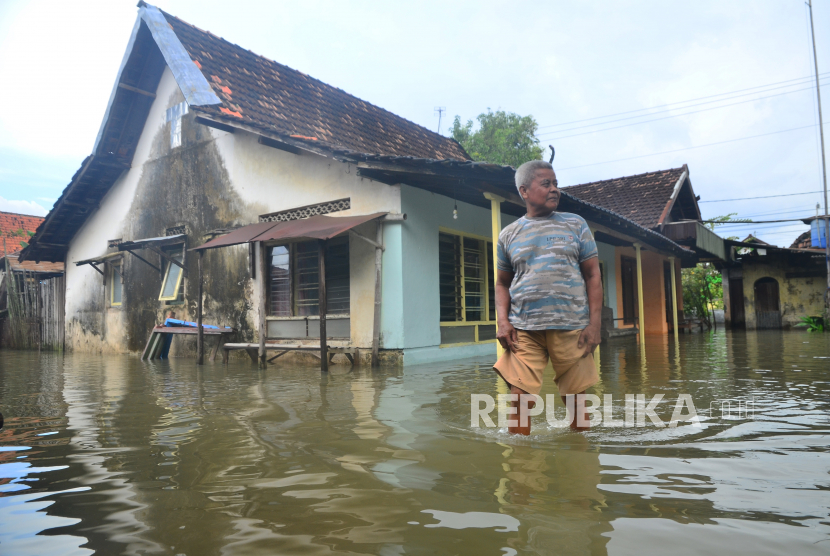Warga berjalan di depan rumah yang tergenang air di Desa Tanjungkarang, Jati, Kudus, Jawa Tengah, Senin (28/2/2022). (Ilustrasi)