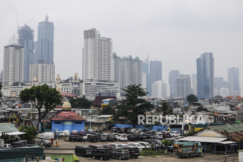 Sejumlah kendaraan parkir dengan latar belakang gedung bertingkat yang diselimuti kabut polusi di Jakarta, Jumat (1/4/2022). Polusi udara luar ruangan yang memburuk dan keracunan timbal telah membuat kematian global akibat pencemaran lingkungan diperkirakan mencapai sembilan juta per tahun sejak 2015.