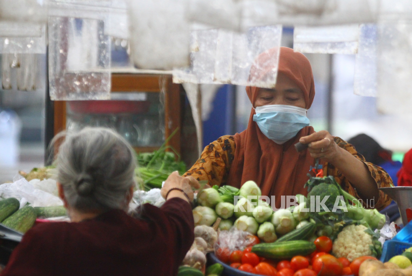 Pedagang melayani pembeli di Pasar Klojen, Malang, Jawa Timur, Jumat (6/8/2021). Pemerintah setempat membebaskan retribusi pelayanan pasar rakyat bagi para pedagang guna mengurangi dampak penerapan Pemberlakuan Pembatasan Kegiatan Masyarakat (PPKM) yang merupakan upaya pemerintah untuk mengendalikan penyebaran COVID-19. 