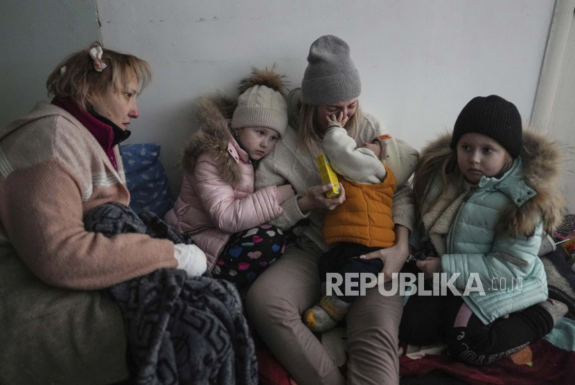  Wanita dan anak-anak duduk di lantai koridor di sebuah rumah sakit di Mariupol, Ukraina timur. Jepang telah kirimkan robot ke Polandia untuk atasi trauma anak Ukraina akibat perang. Ilustrasi.