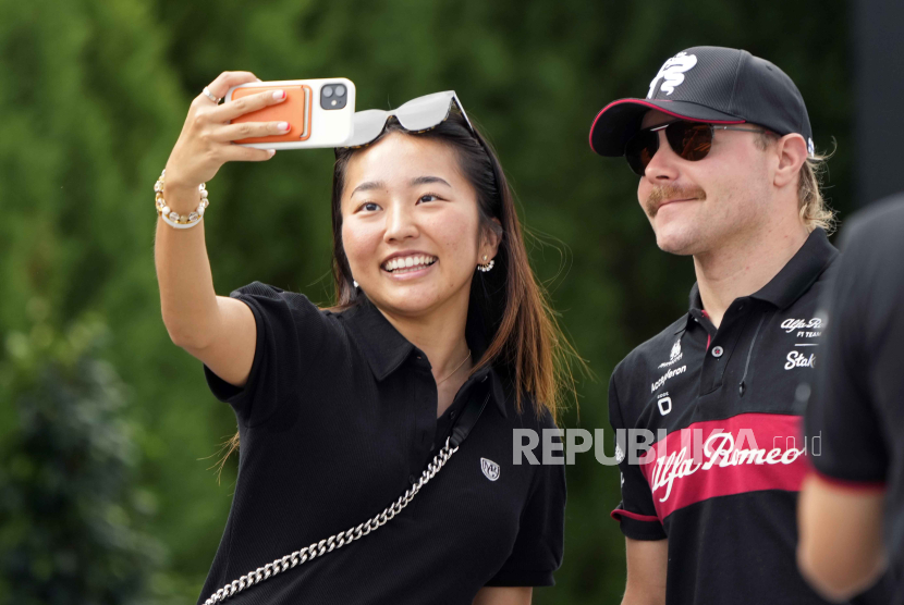 Seorang fan berswafoto dengan pembalap Formula One, Valtteri Bottas (R).