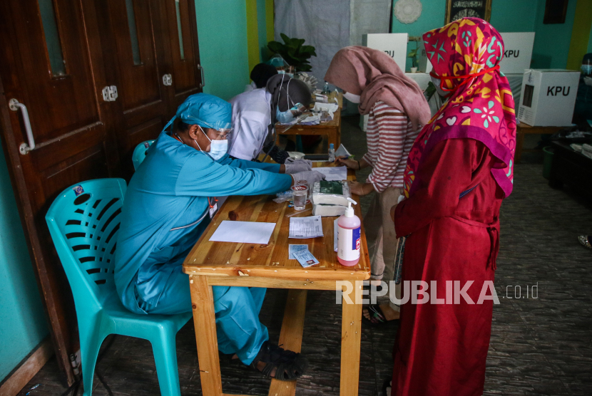 Warga menggunakan hak pilih di TPS 68, Pondok Maharta, Kota Tangerang Selatan, Banten, Rabu (9/12).