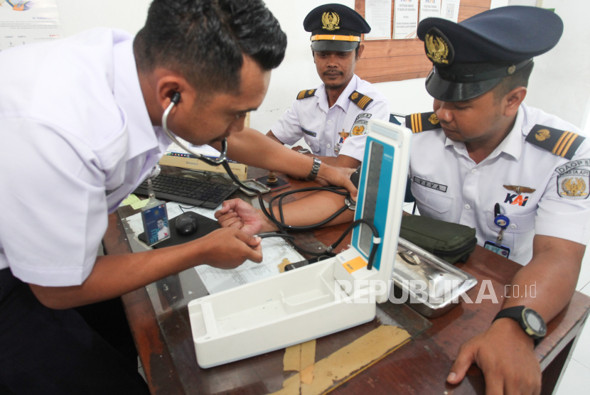 Petugas kesehatan mengukur tekanan darah masinis di Stasiun Sidotopo, Surabaya, Jawa Timur. 
