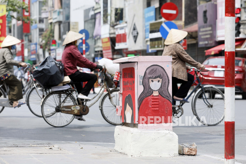 Orang-orang melewati kotak listrik yang dicat dengan tema COVID-19 di Hanoi, Vietnam, 07 Juni 2021. Rakyat Vietnam dikejutkan oleh sekte sesat yang berasal dari Korea Selatan (Korsel) yang meluas di sejumlah provinsinya. 