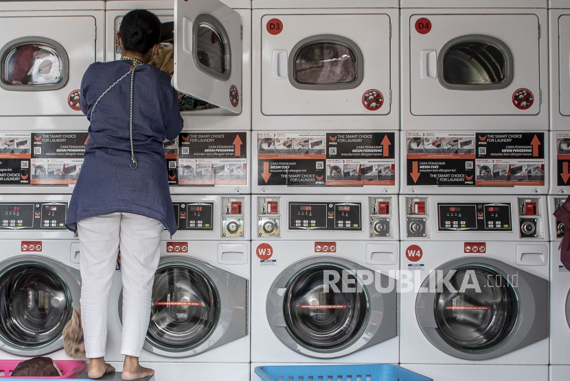 Warga menggunakan mesin cuci listrik di tempat jasa pencucian pakaian di Tangerang, Banten, Ahad (26/6/2022). Sejumlah asosiasi UMKM menilai usulan PLN terhadap pelaku industri rumahan agar pindah ke golongan listrik untuk bisnis dan industri terkait rencana kenaikan tarif dasar listik, hanya akan menyulitkan pelaku usaha kecil karena memindahkan daya membutuhkan biaya serta tak ada jaminan kenaikan tarif jika mereka pindah. 