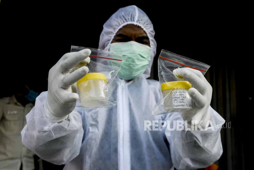 Petugas memperlihatkan wadah sampel dahak milik warga yang menjalani tes Polymerase Chain Reaction (PCR) di perbatasan Jakarta-Bekasi, Lubang Buaya, Jakarta, Selasa (5/5).Tes PCR secara random untuk 50 masyarakat yang melintas di titik perbatasan antara Jakarta dan Bekasi itu untuk mendeteksi lokasi dan menekan penyebaran virus Corona