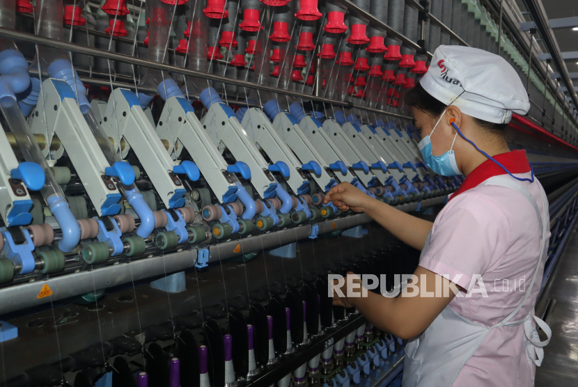 Seorang pekerja Huafu Textile Co Ltd dari etnis minoritas Uighur memeriksa mesin produksi benang di perusahaannya di Prefektur Aksu, Daerah Otonomi Xinjiang, China, Selasa (20/4/2021). Huafu mengalami kerugian hingga 400 juta yuan sejak terkena sanksi dari Kementerian Perdagangan Amerika Serikat sejak Desember 2020 terkait isu kerja paksa terhadap etnis minoritas Uighur. 