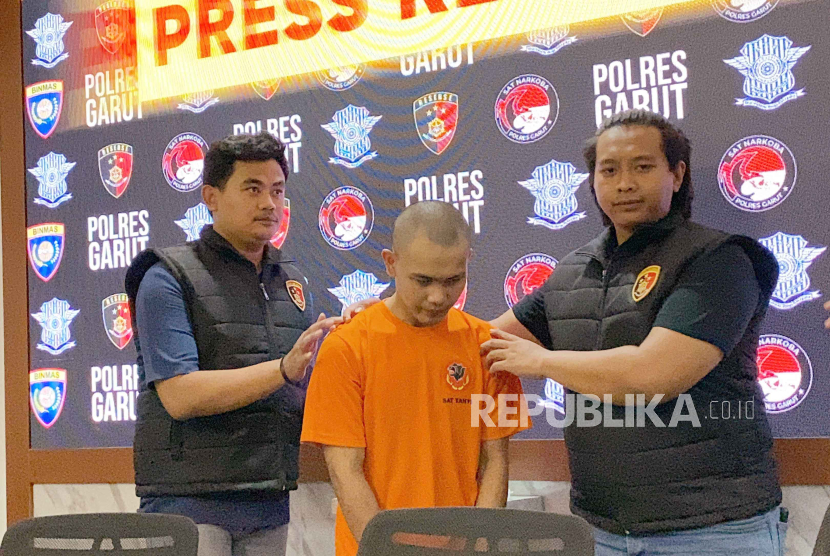Tersangka kasus pembunuhan akibat hubungan sesama jenis digiring polisi saat konferensi pers di Polres Garut, Rabu (13/12/2023). 