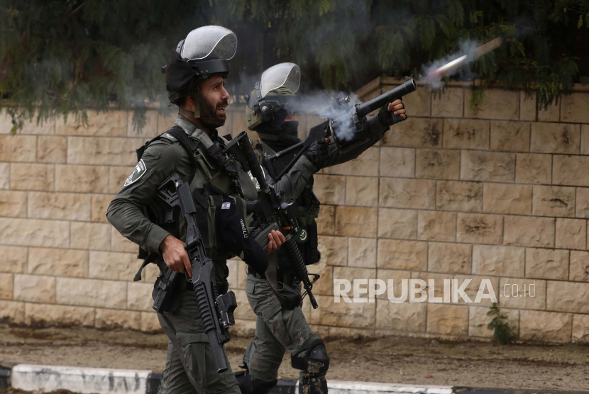 Tentara Israel menembakkan gas air mata ke warga Palestina selama bentrokan di desa Burqa dekat kota Nablus, Tepi Barat, 23 Desember 2021. Bentrokan meletus setelah pemukim Israel tiba untuk memprotes di dekat desa tempat seorang pemukim dibunuh pekan lalu oleh warga Palestina.