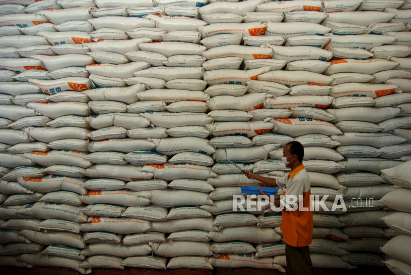 Pekerja memeriksa kualitas beras di Gudang Perum Bulog 