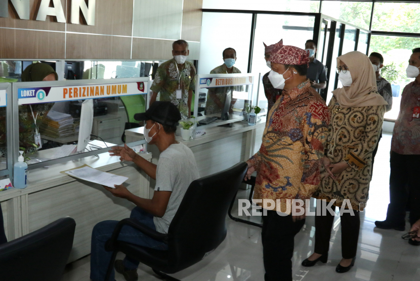 Menteri Dalam Negeri Tito Karnavian (tengah) didampingi Bupati Banyuwangi Ipuk Fiestiandani Azwar Anas  (kanan) melihat proses pelayanan administrasi kependudukan di Mall Pelayanan  Publik Banyuwangi, Jawa Timur, Jumat (4/6/2021). 