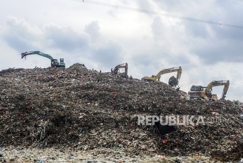 Sejumlah alat berat memindahkan tumpukan sampah di Tempat Pembuangan Akhir (TPA) Cipayung, Depok, Jawa Barat, Selasa (24/5/2022). TPA seluas 11,2 hektare tersebut telah menampung 2,5 juta meter kubik sampah yang seharusnya hanya dapat menampung 1,3 juta meter kubik yang dikhawatirkan dapat memicu terjadinya longsoran sampah sehingga menyebabkan operasional truk sampah terganggu. 