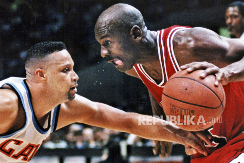  FILE - Michael Jordan dari Chicago Bulls, kanan, melakukan tembakan melawan Chris Mills dari Cleveland Cavaliers selama pertandingan bola basket NBA di Coliseum di Richfield, Ohio, pada tahun 1994.