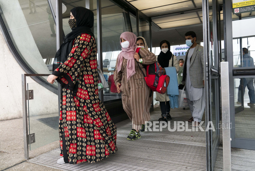 Keluarga yang dievakuasi dari Kabul, Afghanistan, berjalan melewati terminal sebelum naik bus setelah mereka tiba di Bandara Internasional Washington Dulles, di Chantilly, Va, pada Minggu, 29 Agustus 2021.