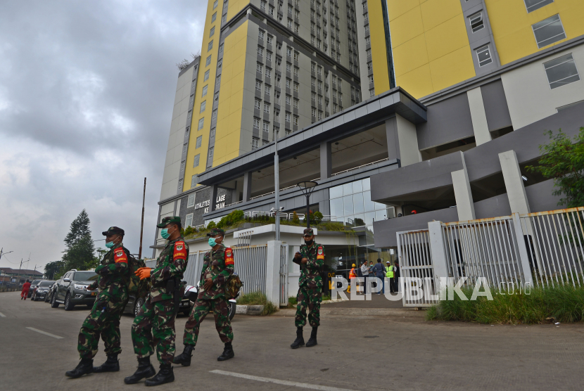 Prajurit TNI berjaga di depan Rumah Sakit Darurat Wisma Atlet, Kemayoran, Jakarta Pusat, Kamis (19/3). 