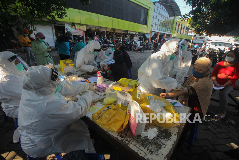 Petugas melakukan pemeriksaan cepat COVID-19 (Rapid Test) terhadap warga di Pasar Kembang, Surabaya, Jawa Timur, Rabu (13/5). Pemeriksaan cepat terhadap sejumlah pedagang di pasar itu guna mengetahui kondisi kesehatan mereka sebagai upaya untuk mencegah penyebaran virus Corona (COVID-19)