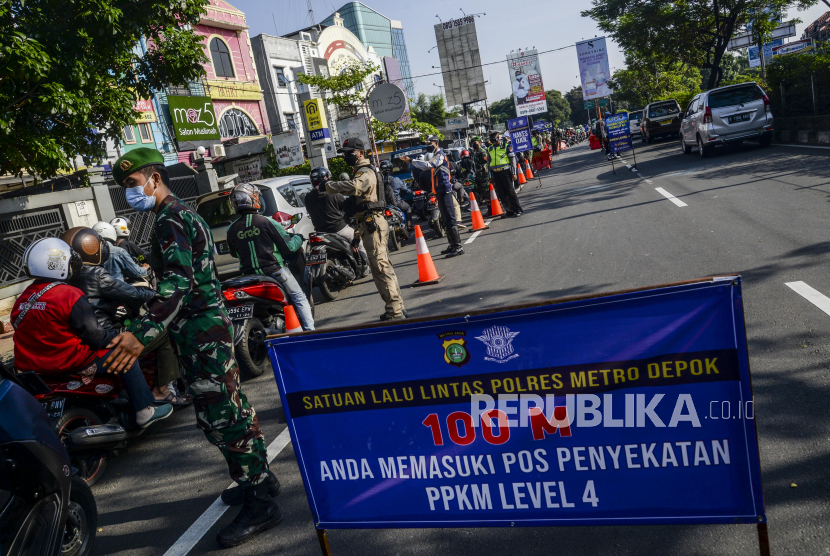 Petugas gabungan mengatur lalu lintas saat dilakukan penyekatan di Jalan Raya Margonda, Depok, Jawa Barat, Senin (2/8).