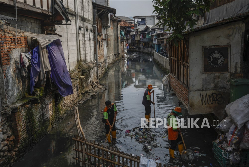 Para pekerja membersihkan saluran air yang tercemar di daerah kumuh Jakarta, Senin (22/5/2023). Tingkat kemiskinan Indonesia diperkirakan akan berkurang menjadi 6,5 hingga 7,5 persen pada tahun 2024, kata Menteri Keuangan Sri Mulyani Indrawati dalam pertemuan dengan Dewan parlemen pada 19 Mei.