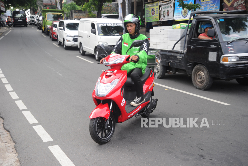 Pengemudi Ojek online mengendarai motor listrik ECGO 3 di Jakarta.