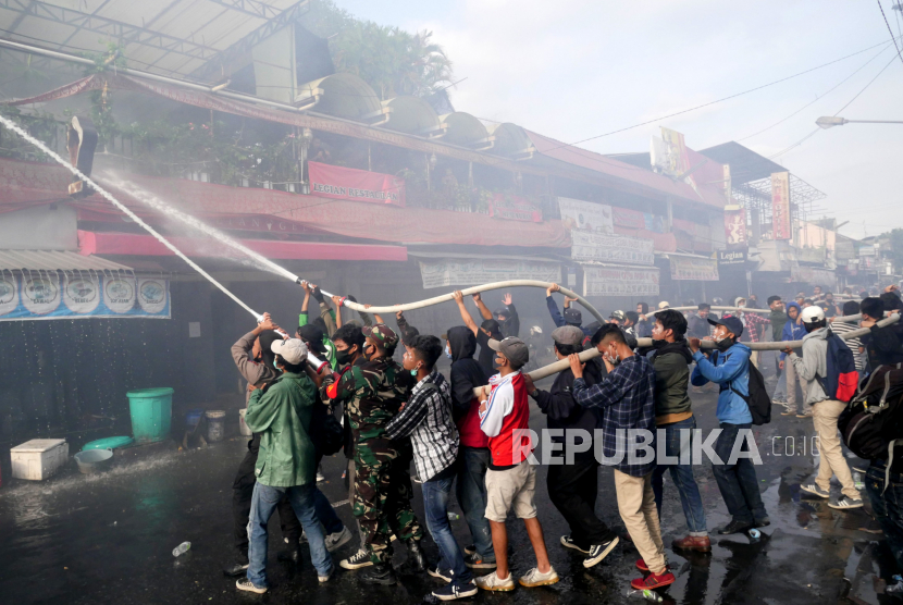 Polisi Sebut Kericuhan Aksi di Malioboro karena Ikut-Ikutan. Foto: Petugas memadamkan api ruko yang terbakar saat unjuk rasa tolak Omnibus Law  di Malioboro, Yogyakarta, Kamis (8/10).