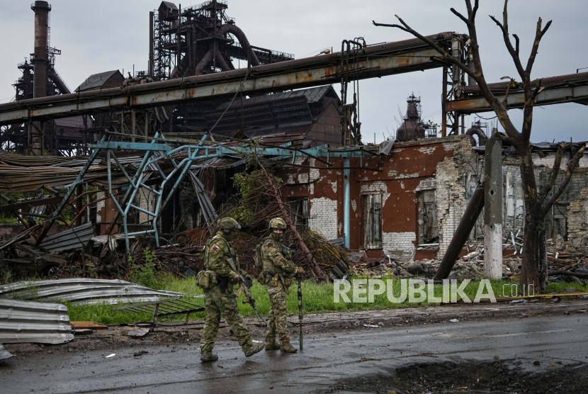 Tentara Rusia berpatroli di bagian yang hancur dari Pabrik Metalurgi Pekerjaan Besi & Baja Illich di Mariupol, di wilayah di bawah pemerintahan Republik Rakyat Donetsk, Ukraina timur, Rabu, 18 Mei 2022. Miliarder Ukraina pemilik pabrik baja yang dibom Rusia akan ajukan ganti rugi perang. Ilustrasi.