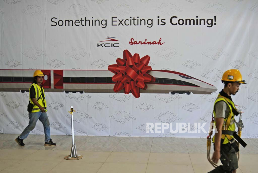 Workers walk past a banner at the construction site of Halim Station ahead of an operational test run of the Jakarta-Bandung high-speed train in September, in Jakarta, Indonesia, Saturday, Aug. 12, 2023. The first high-speed rail service in Southeast Asia, which is being constructed by PT Kereta Cepat Indonesia-China (PT KCIC), a joint venture between an Indonesian consortium of four state-owned companies and China Railway International Co. Ltd., is part of China