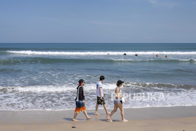 Wisatawan berjalan-jalan di Pantai Kuta, Bali. BMKG meminta masyarakat mewaspadai potensi banjir pesisir atau rob di 24 pantai di Bali.