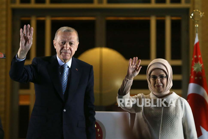 Turkish President Recep Tayyip Erdogan (L), with his wife Ermine Erdogan, acknowledges supporters after winning re-election in Turkey